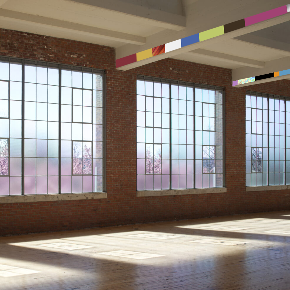 horizon of brightly colored strips of vinyl of random color and length displayed across the length of the wall on cross beams at the where wall becomes ceiling as if in the dia beacon by noah phillips with pink spring blossoms outside the robert irwin windows